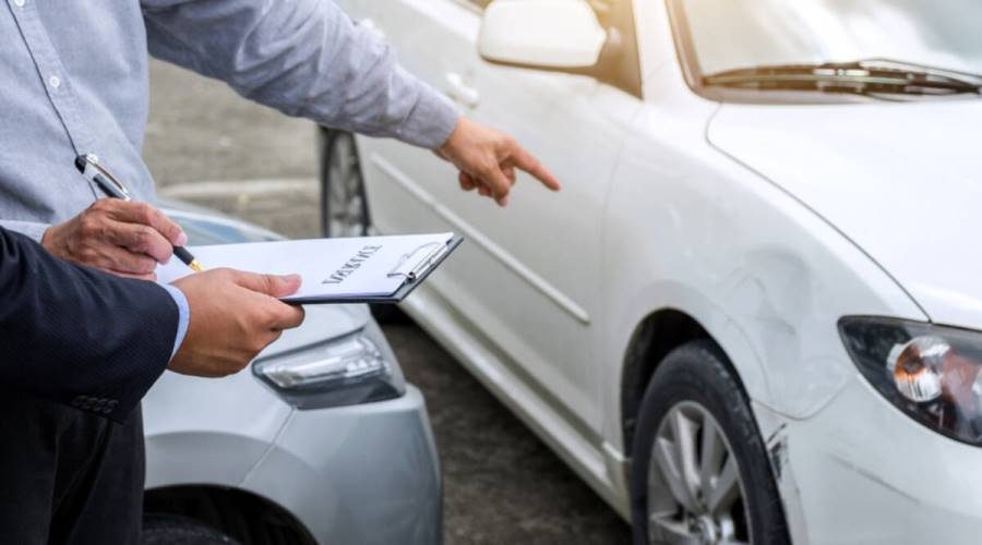 Insurance Agent examine Damaged Car and filing Report Claim Form after accident, Traffic Accident and insurance concept.